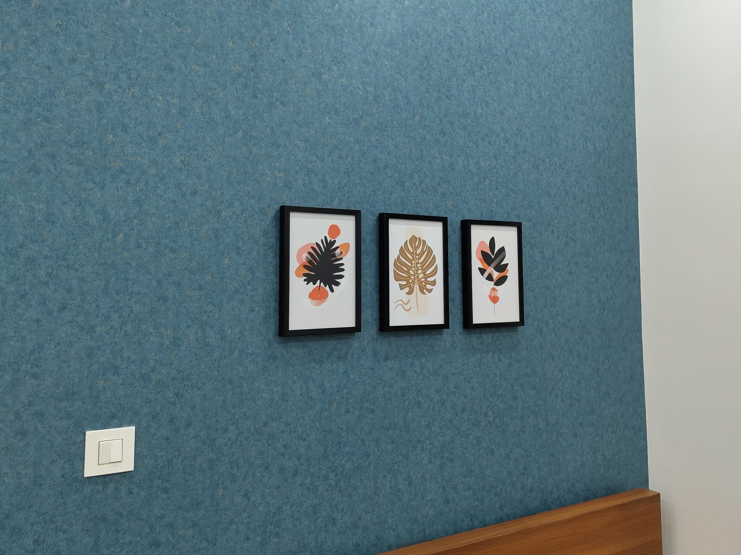 Blue textured wallpaper with framed artwork