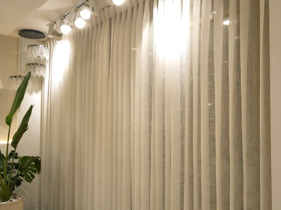Sheer white floor length curtains with pleated design